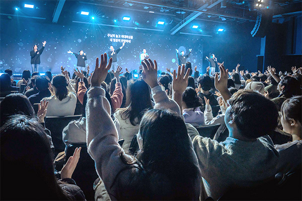 컴패션 기도무브먼트 콘서트 현장에 사람들이 손을 들고 콘서트에 열광하며 콘서트를 즐기고있다